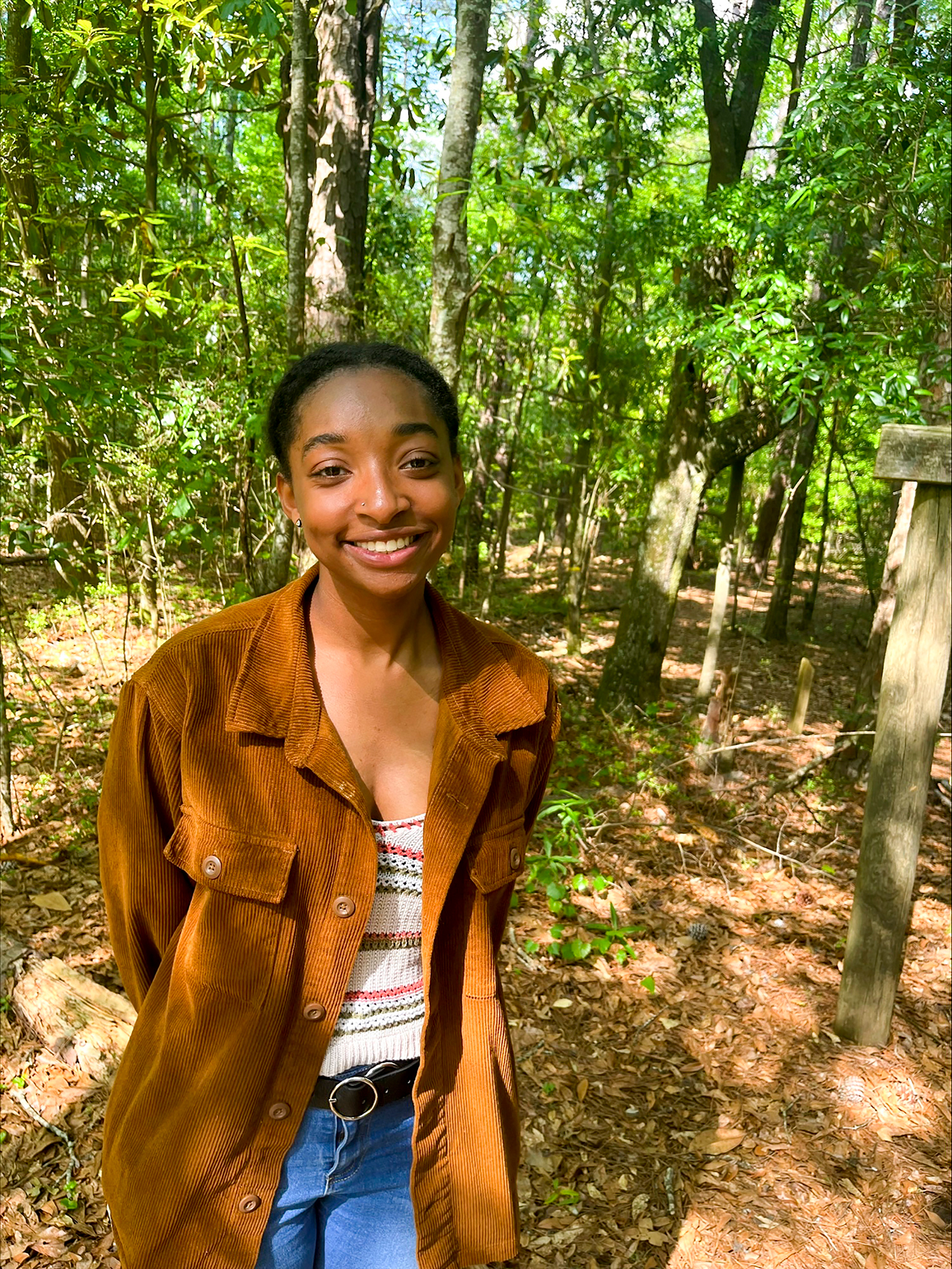 Portrait photo of Jameia Boone surrounded by trees and greenery in the forest.
